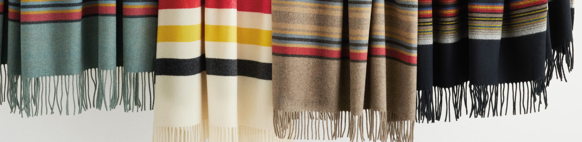 Four 5th Avenue throws hanging on a bar