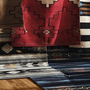 Stack of colorful Pendleton rugs