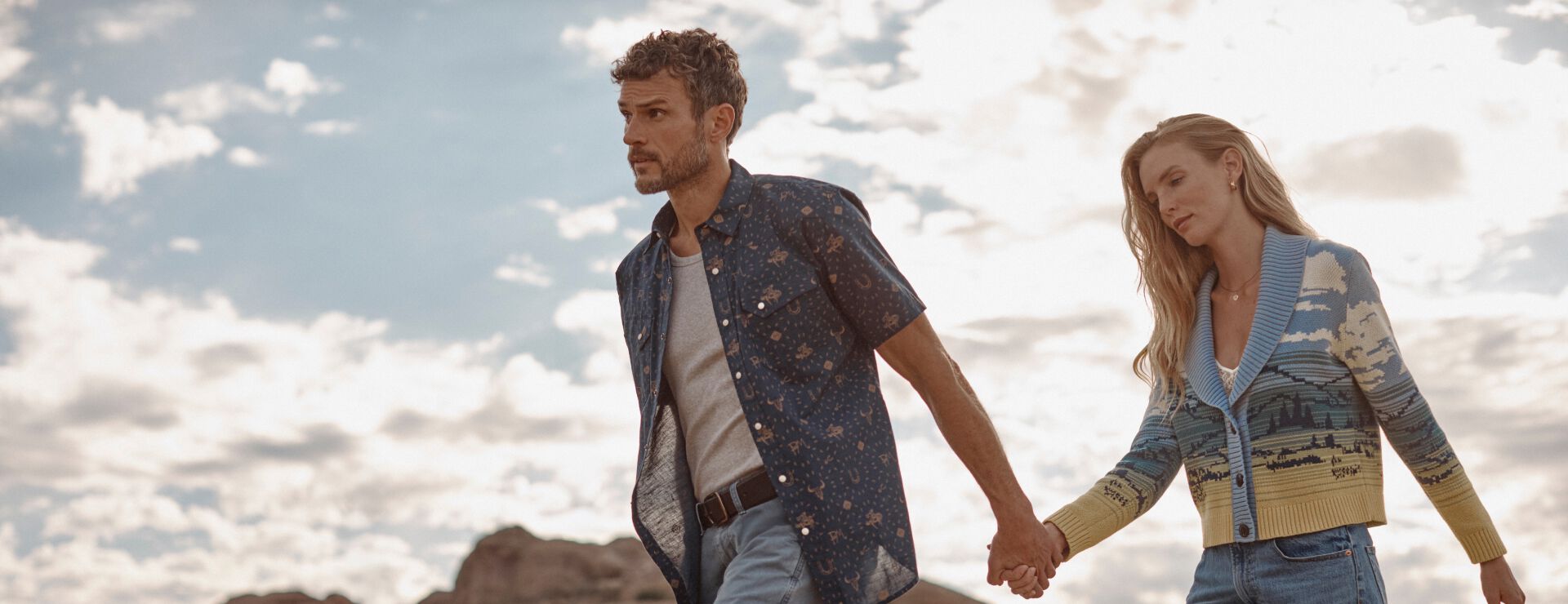 Man and woman walking outside wearing Pendleton shirt and sweater