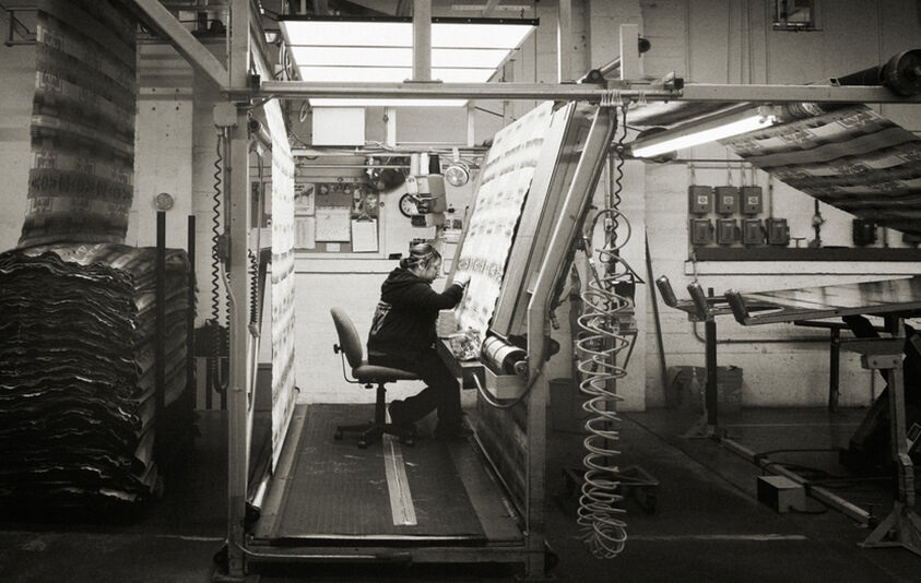 black and white photo of women at loom