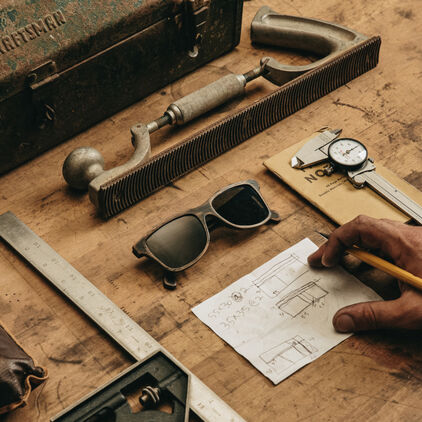 Schwood collaboration glasses on a workbench with drafting items around them
