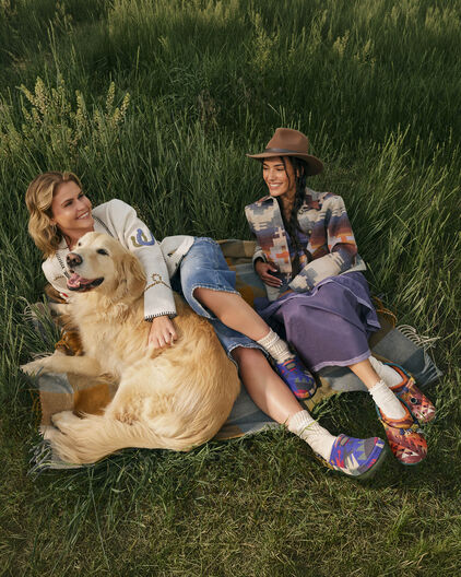 Two women outside wearing Crocs x Pendleton clogs
