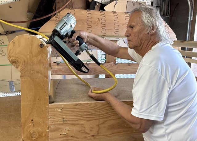 Artist Ernie Apodaca working on the wood frame of a chair